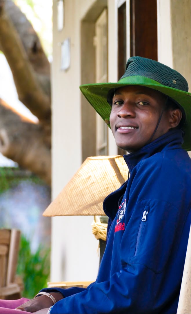 Anthony smiling outdoors in a denim jacket and scarf